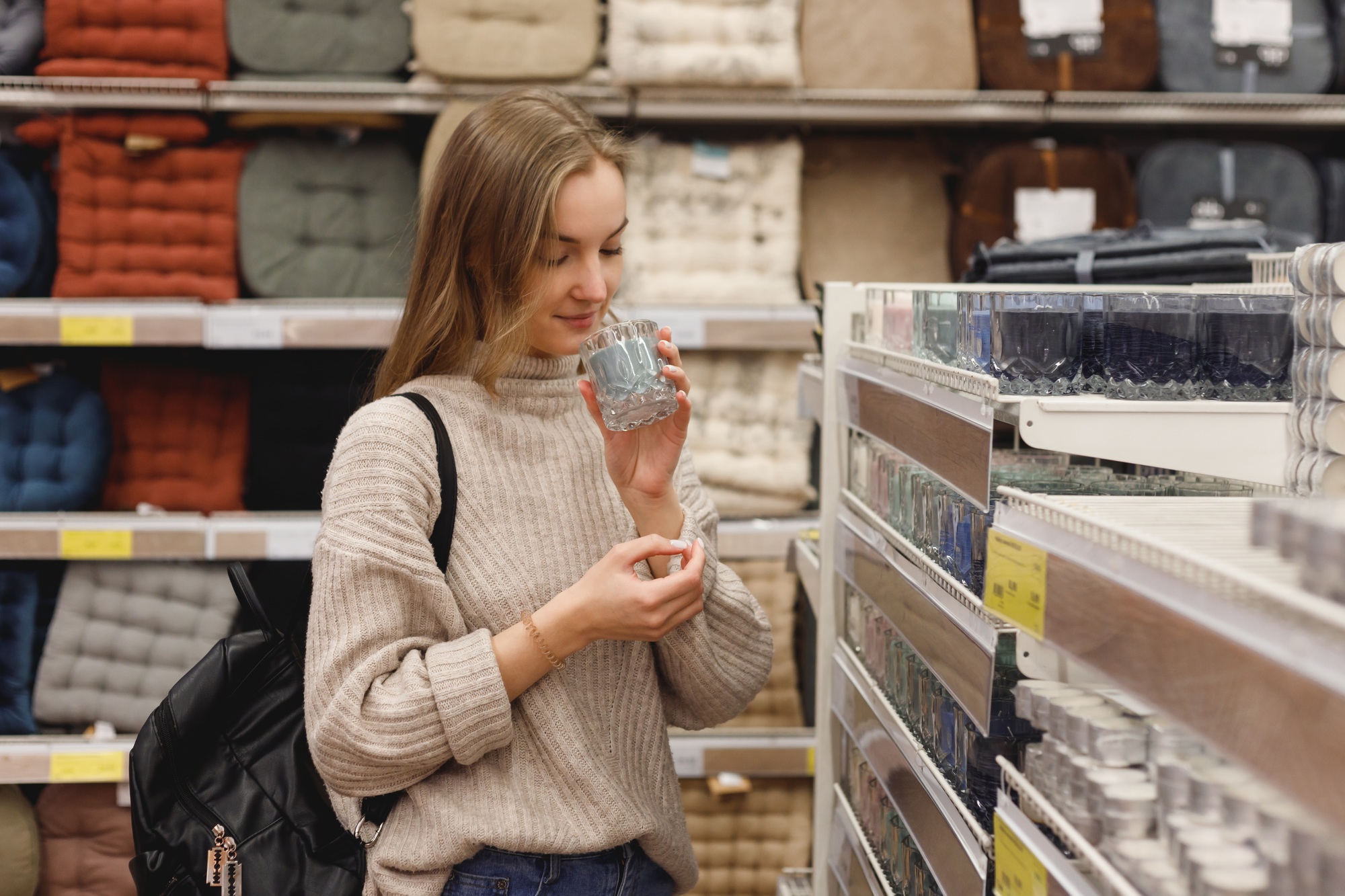 Young woman chooses scented candles for home at mall